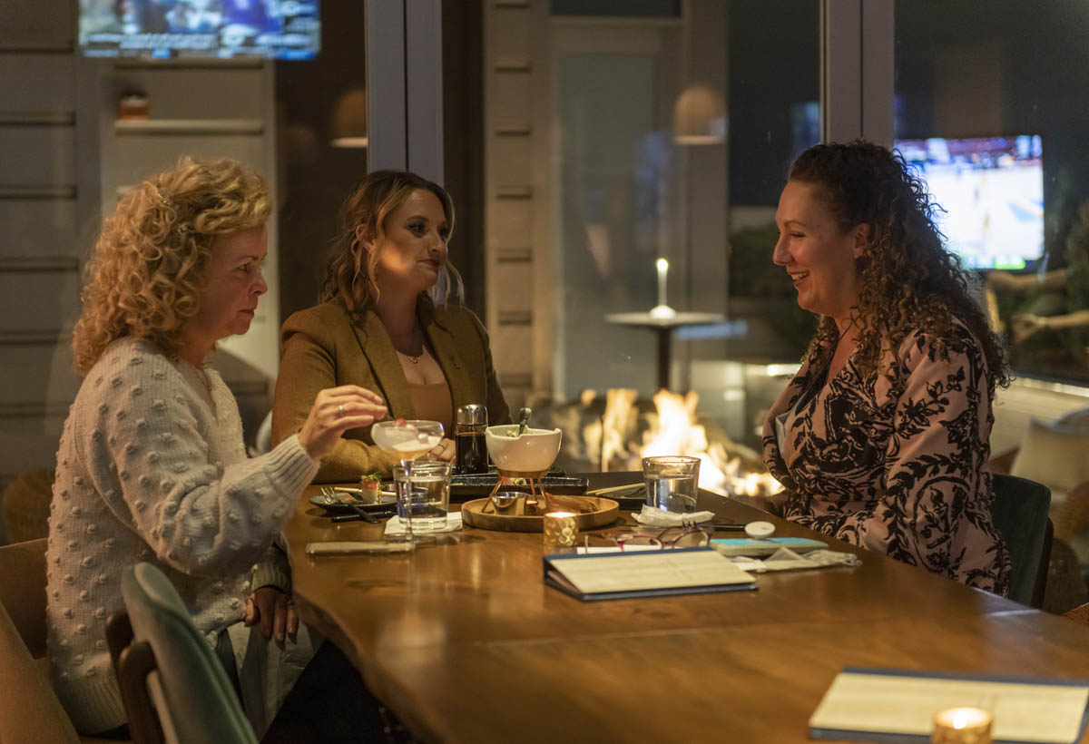 Three women enjoying food and cocktails at Prime Social preview party