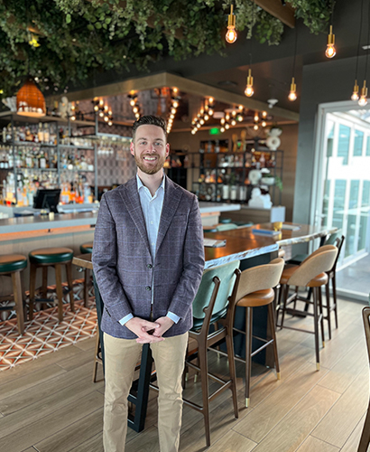 General Manager Collin Winterberg standing adjacent to the bar inside Prime Social in Kansas City, Missouri